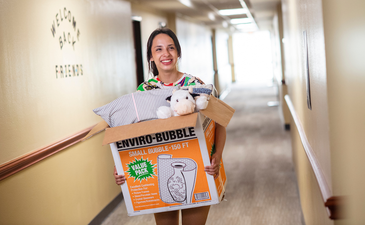 person walking in hall with moving box